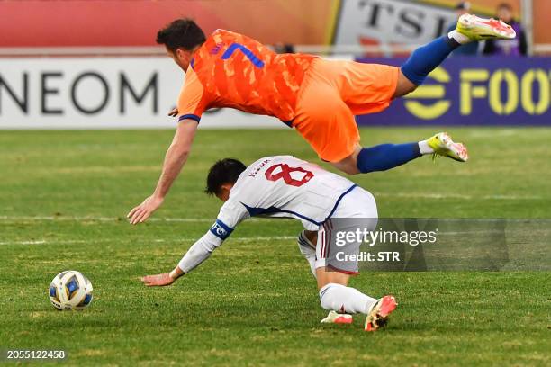 Shandong Taishan's Valeri Qazaishvili fights for the ball with Yokohama's Takuya Kida during the AFC Champions League quarterfinal match between...