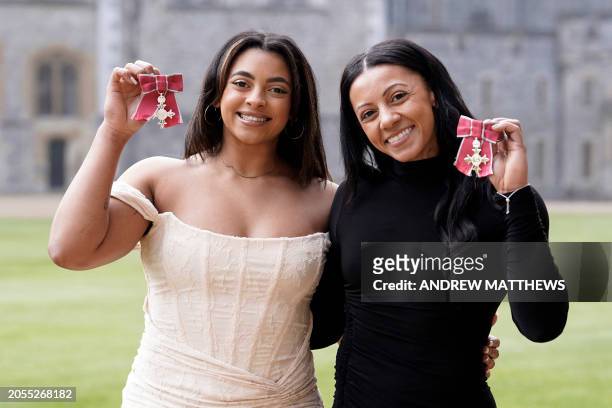 Elissa 'Ellie Downie and Rebecca 'Becky Downie pose with their medals after being appointed Members of the Order of the British Empire following an...