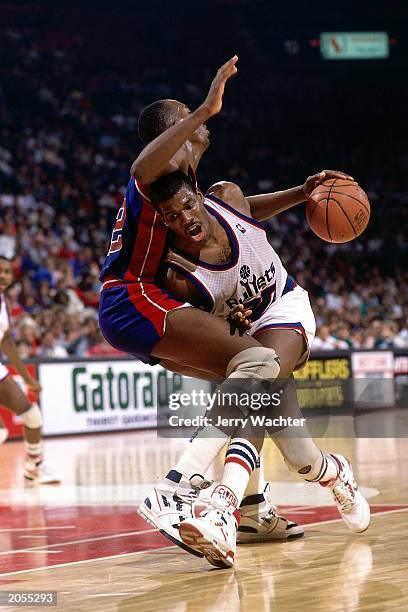 Bernard King of the Washington Bullets dribbles against John Salley of the Detroit Pistons during the 1989 season NBA game at the USAir Arena in...