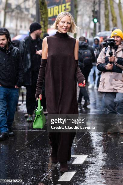 Violet Grace Atkinson, wears brown turtleneck long sweater dress, matching arm warmers, green Hermes bag, outside Hermes, during the Womenswear...