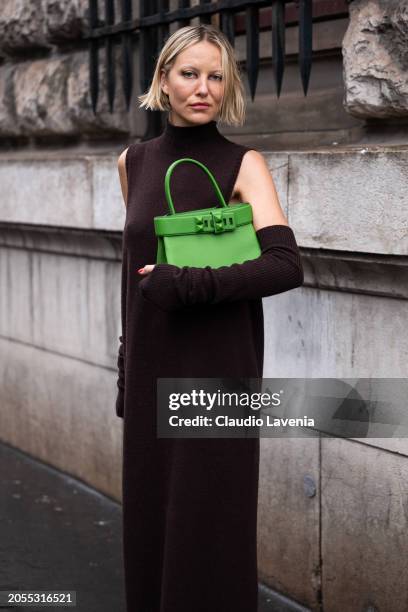 Violet Grace Atkinson, wears brown turtleneck long sweater dress, matching arm warmers, green Hermes bag, outside Hermes, during the Womenswear...