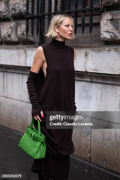 Violet Grace Atkinson, wears brown turtleneck long sweater dress, matching arm warmers, green Hermes bag, outside Hermes, during the Womenswear...