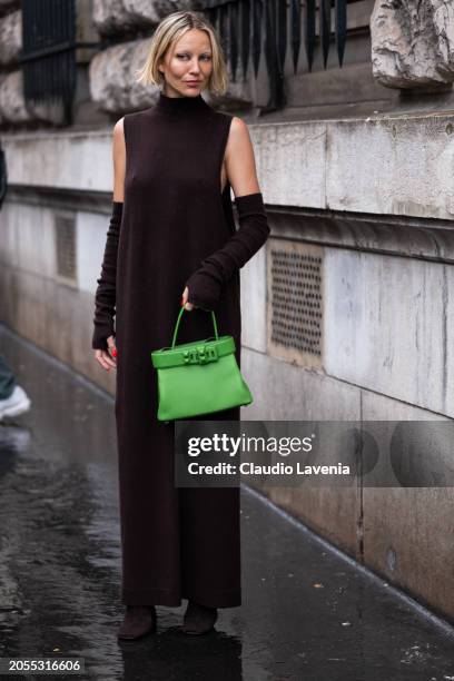 Violet Grace Atkinson, wears brown turtleneck long sweater dress, matching arm warmers, green Hermes bag, outside Hermes, during the Womenswear...