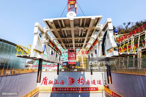 Shield tunneling machine weighing over 100 tons is lifted into a well at the construction site of Jintang undersea tunnel linking the Jintang islet...