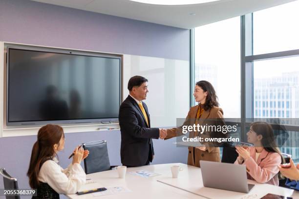 happy businessmen shaking hands on a meeting in the office - old shanghai stock pictures, royalty-free photos & images