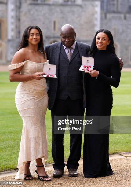 British gymnasts Elissa Downie and Rebecca Downie pose with their father Anthony after being made Members of the Order of the British Empire during...