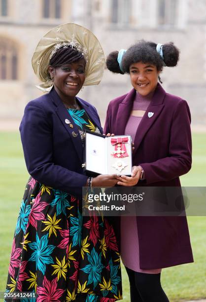 Dame Margaret Aderin-Pocock poses for a photograph with her daughter Lori after being made a Dame Commander of the British Empire during an...