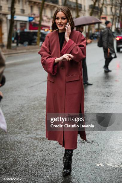 Olivia Palermo, wears red coat, black vinyl boots, outside Hermes, during the Womenswear Fall/Winter 2024/2025 as part of Paris Fashion Week on March...