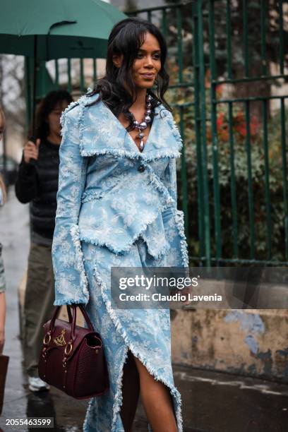 Khaoula Madi, wears light blue decorated jacket with matching skirt, burgundy Vivienne Westwood bag, outside Vivienne Westwood, during the Womenswear...