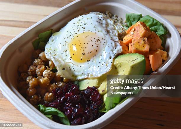 Dragon bowl with coconut quinoa, roasted sweet potatoes, fried cumin chickpeas, fried egg, Thai peanut dressing, avocado and toasted coconut at...