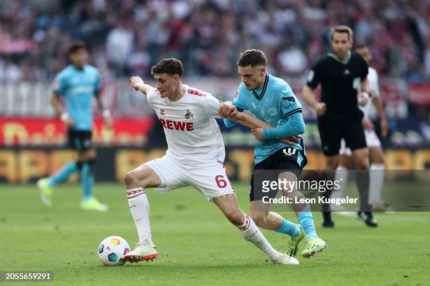 Eric Martel of 1.FC Köln is challenged by Florian Wirtz of Bayer Leverkusen during the Bundesliga match between 1. FC Köln and Bayer 04 Leverkusen at...