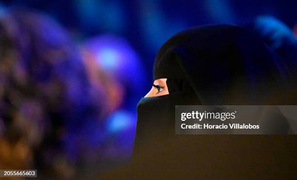 Young woman wearing a niqab listens to a presentation during Xposure on March 03 in Sharjah, United Arab Emirates. Xposure International Photography...
