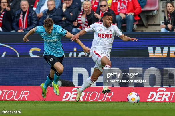 Josip Stanisic of Bayer 04 Leverkusen and Linton Maina of 1. FC Koeln battle for the ball during the Bundesliga match between 1. FC Köln and Bayer 04...