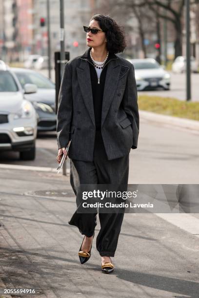 Caroline Issa wears black jumper, grey suit, black heels with gold details, black and gold sunglasses, outside Ferragamo, during the Milan Fashion...