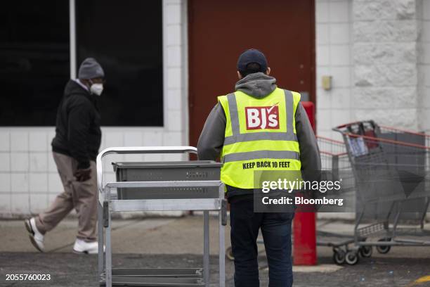 Worker pushes a cart outside a BJ's Wholesale Club location in Albany, New York, US, on Monday, March 4, 2024. BJ's Wholesale Club Holdings Inc. Is...