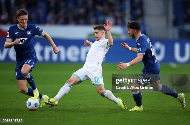 Romano Schmid of SV Werder Bremen is challenged by Umut Tohumcu and Marius Buelter of TSG 1899 Hoffenheim during the Bundesliga match between TSG...