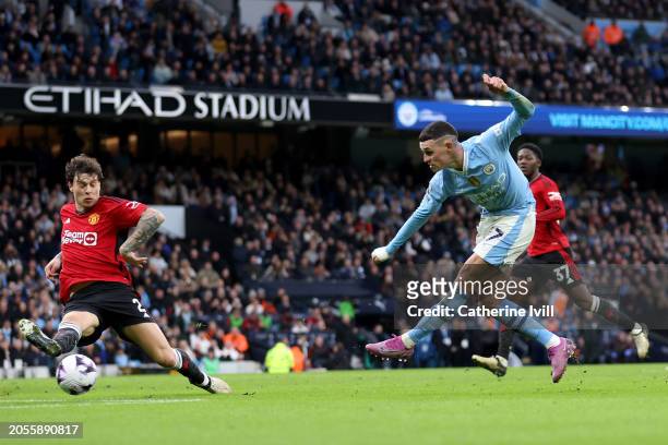 Phil Foden of Manchester City scores his team's first goal during the Premier League match between Manchester City and Manchester United at Etihad...