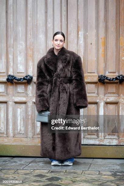 Charlotte Groeneveld wears a brown oversized fluffy fur coat, a gray Hermes Kelly bag, outside Hermes, during the Womenswear Fall/Winter 2024/2025 as...