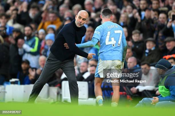 Phil Foden of Manchester City interacts with Pep Guardiola, Manager of Manchester City, after being substituted during the Premier League match...