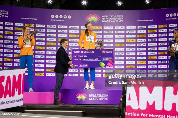 President of the International Association of Athletics Federations, Sebastian Coe presents Gold medalist, Femke Bol of the Netherlands with a cheque...