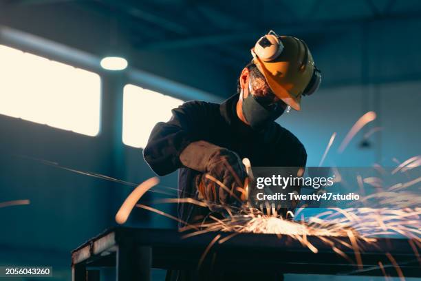 technician cutting an iron pipe with a cutter in the factory - slijptol stockfoto's en -beelden