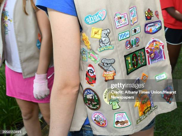 Girl Scout Kathryn Braun wears a vest with merit badges as she helps plant flowers around the entranceway sign for the Albany County Nursing Home on...