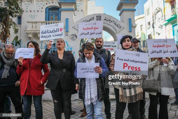 Journalists are raising placards during a rally staged by the National Union of Tunisian Journalists in front of its headquarters in Tunis, Tunisia,...