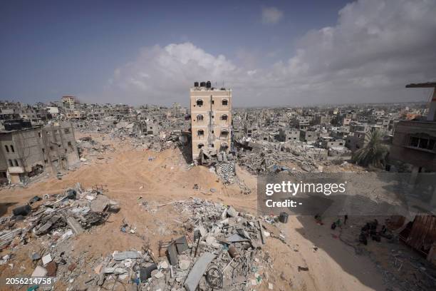 Palestinians stand amid the rubble of houses destroyed by Israeli bombardment in Khan Yunis in the southern Gaza Strip on March 6 amid the ongoing...