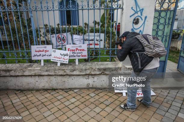 Photographer is taking pictures of placards outside the National Union of Tunisian Journalists' headquarters in Tunis, Tunisia, on March 6, 2024. The...