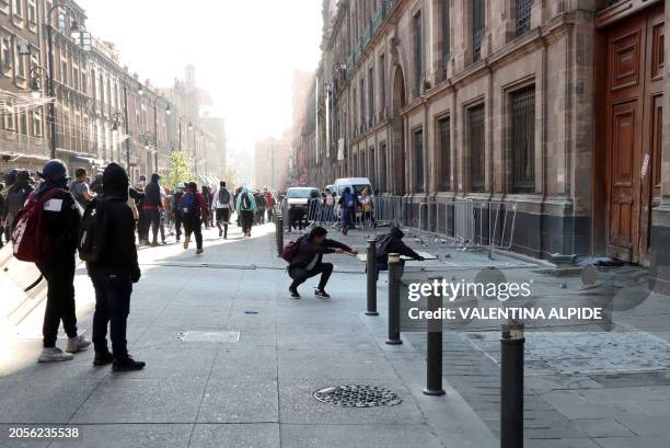 Demonstrators try to break down a presidential palace door in Mexico City on March 6 during a protest over the disappearance of the 43 students of...