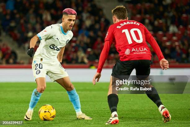 Sergi Darder of RCD Mallorca and Yan Couto of Girona FC competes for the ball during the LaLiga EA Sports match between RCD Mallorca and Girona FC at...