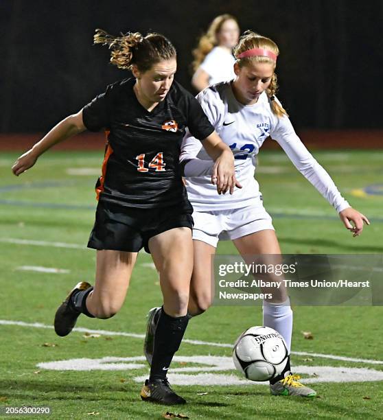 Bethlehem's Grace Hotaling, #14 left, battles for the ball with Saratoga's Autumn Soukup during the Class AA girls' soccer semifinals on Wednesday,...