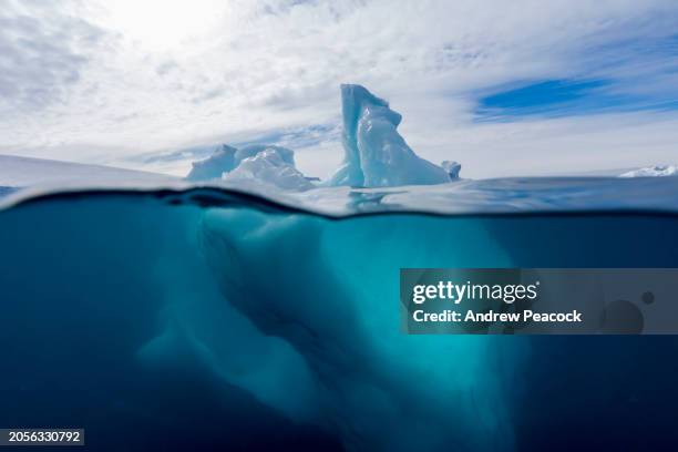 vue sous et au-dessus de l’eau d’un iceberg dans l’antarctique. - changement climatique photos et images de collection