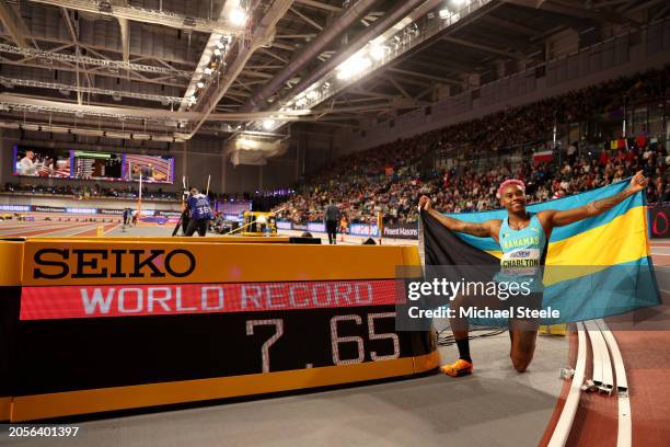 Devynne Charlton of Team Bahamas poses for a photo with the scoreboard after setting a new world record after winning the Women's 60 Metres Hurdles...