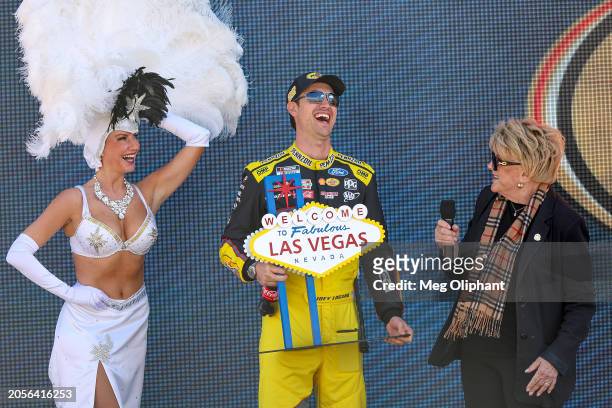 Joey Logano, driver of the Pennzoil Ford, shares a laugh with Las Vegas Mayor Carolyn Goodman onstage during pre-race ceremonies prior to the NASCAR...
