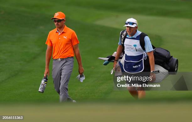 Rickie Fowler of the United States and caddie Ricky Romano walk on the fourth hole during the final round of The Cognizant Classic in The Palm...