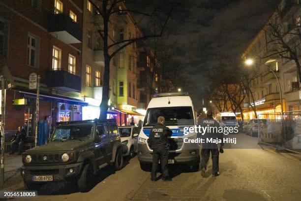 Police officers stand at Gruenberger Strasse in Friedrichshain district where they had stormed an apartment earlier tonight in the search for...
