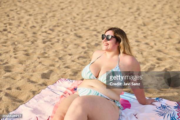 fröhliche übergewichtige frau sonnt sich am sandstrand - big fat white women stock-fotos und bilder