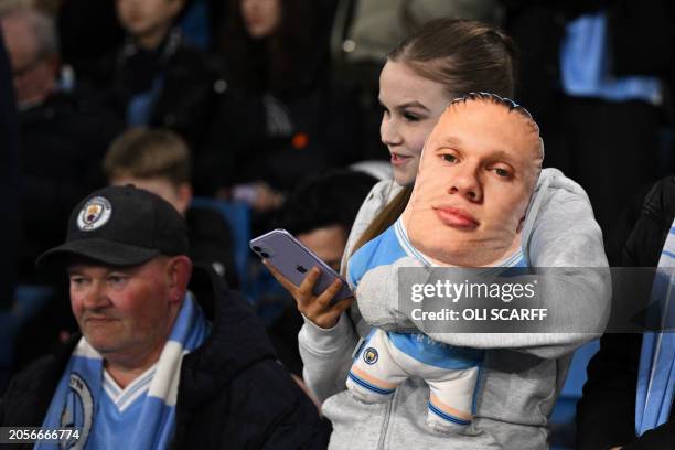 City fan cuddles a soft-toy Erling Haaland in the crowd ahead of the UEFA Champions League round of 16, second-leg, football match between Manchester...