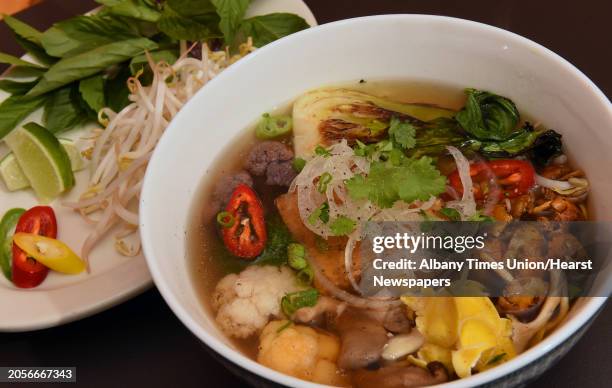 Vegan noodle soup tofu, broccoli, cauliflower, cabbage, carrot, oyster mushrooms, traditional Vietnamese rice noodle soup with scallion, onion,...