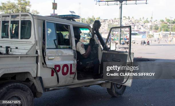 Graphic content / Police officers control the perimeter of the police station set on fire the previous day by armed gangs, in Port-au-Prince, Haiti,...