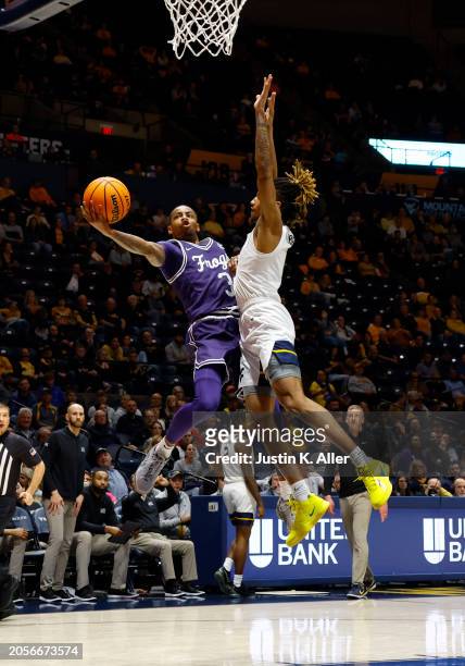 Avery Anderson III of the TCU Horned Frogs drives against Noah Farrakhan of the West Virginia Mountaineers in the first half at the WVU Coliseum on...