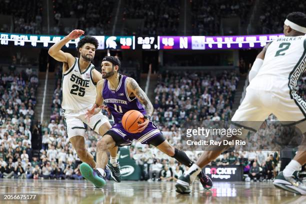 Boo Buie of the Northwestern Wildcats drives past Malik Hall of the Michigan State Spartans during the second half at Breslin Center on March 6, 2024...