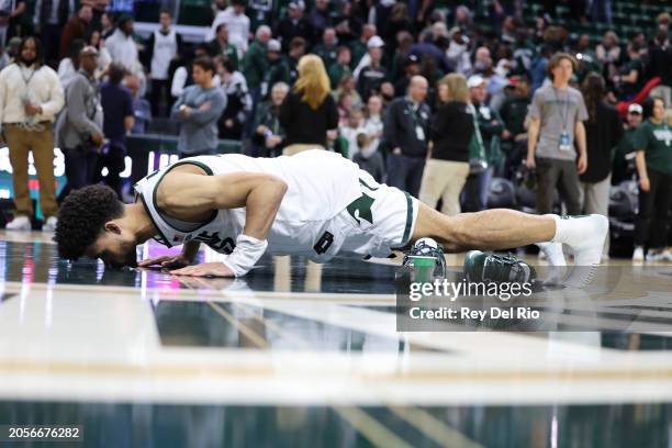 Malik Hall of the Michigan State Spartans kisses the center court logo on senior day after the game against the Northwestern Wildcats between the...