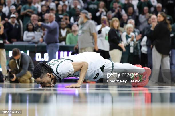 Davis Smith of the Michigan State Spartans kisses the center court logo on senior day after the game against the Northwestern Wildcats between the...