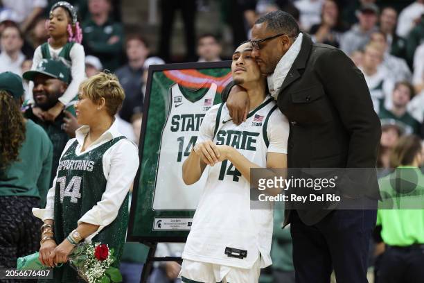 Davis Smith of the Michigan State Spartans is hugged by his father, former Spartans player Steve Smith on senior day after the game against the...