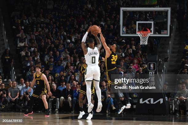 Damian Lillard of the Milwaukee Bucks shoots a three point basket during the game as Stephen Curry of the Golden State Warriors plays defense on...