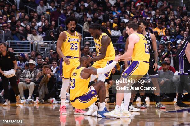 Taurean Prince and Austin Reaves helped up LeBron James of the Los Angeles Lakers during the game against the Sacramento Kings on March 6, 2024 NBAE...