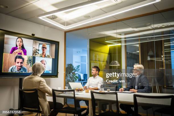 business people attending a hybrid presentation - interactief stockfoto's en -beelden