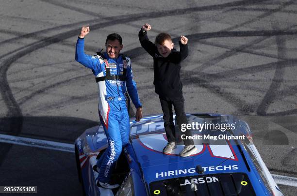 Kyle Larson, driver of the HendrickCars.com Chevrolet, celebrates with his son, Owen Larson after winning the NASCAR Cup Series Pennzoil 400 at Las...